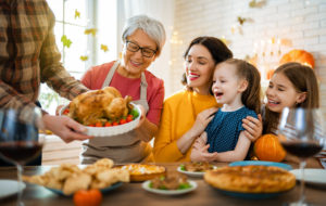 grandparents, daughter and grandchildren around a Thanksgiving table